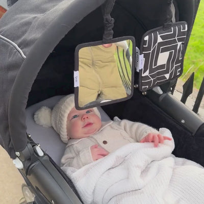 baby in pram staring at hanging squares