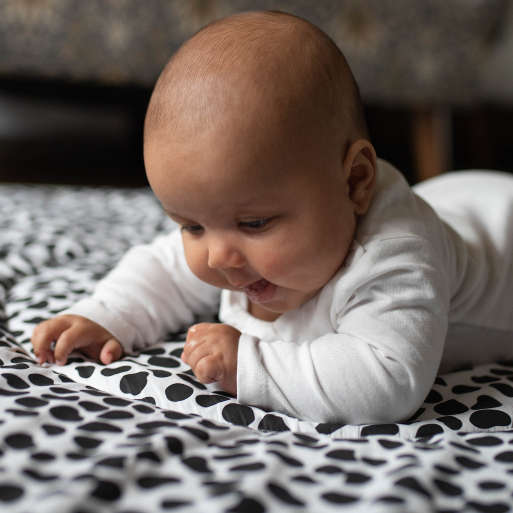 Baby staring at sensory playmat designed by experts in children's visual development  